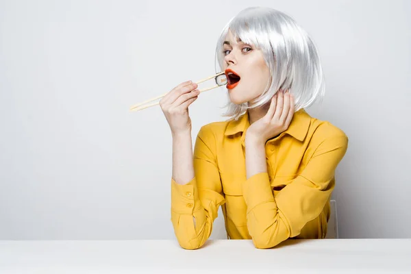 Ελκυστική γυναίκα που τρώει σούσι με ξυλάκια περούκας — Φωτογραφία Αρχείου