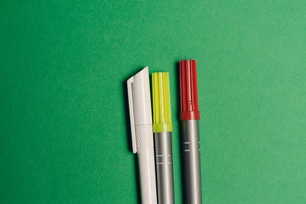 Multicolored pens on a green background office supplies work stationery — Stock Photo, Image