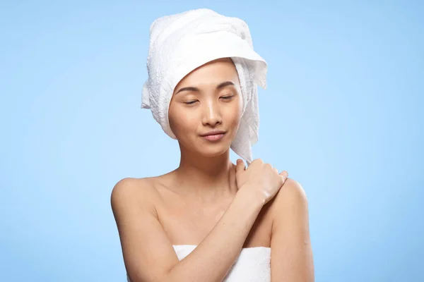 Hübsche Frau nackte Schultern Handtuch auf dem Kopf saubere Hautpflege blauer Hintergrund — Stockfoto