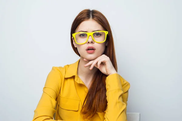 Vrolijke vrouw zitten aan de tafel stok met hart geel shirt — Stockfoto