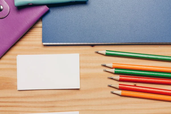 Tarjetas de visita lápices de colores escritorio papelería vista superior — Foto de Stock
