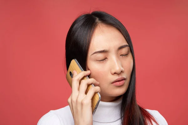 Жінка азіатська зовнішність говорить на телефоні технології способу життя червоний фон — стокове фото