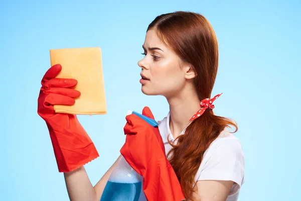 Profissional de limpeza senhora detergente com um pano em suas mãos trabalhando como fundo azul — Fotografia de Stock