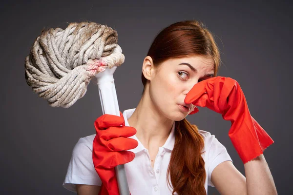 Limpieza señora cubre su nariz con sus dedos desagradable olor fregona en la mano limpieza descontento — Foto de Stock