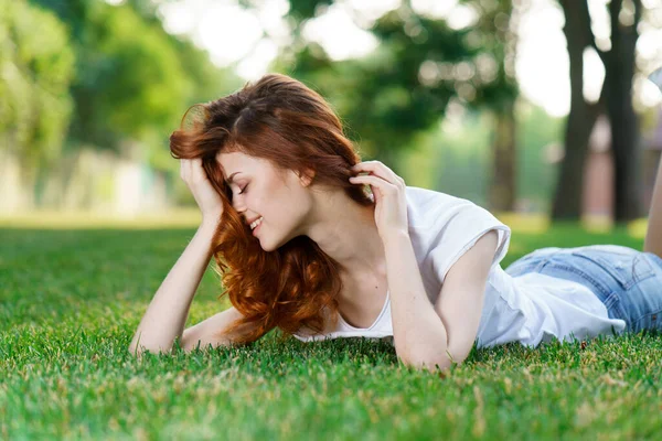 Frau liegt auf dem Gras im Park — Stockfoto