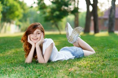 Neşeli kadın çimenlerin üzerinde uzanıyor taze hava parkı eğlence yaşam tarzı özgürlük