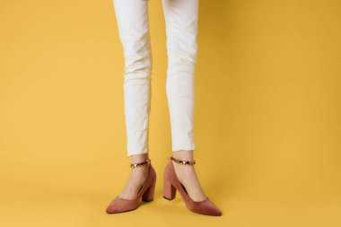 Kadın ayakları moda ayakkabıları lüks sarı arka plan