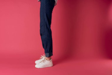 Kadınların ayakları beyaz spor ayakkabılar moda sokak tarzı pembe arka plan
