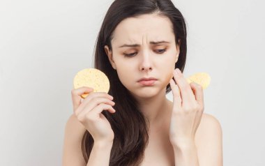 Esmer, çıplak omuzlu, sünger tutan.