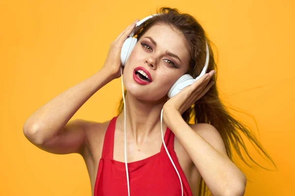 Женщина в наушниках слушает музыку эмоции стиль жизни весело желтый фон — стоковое фото