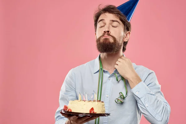 Homem barbudo com bolo em fundo rosa festa de aniversário emoções corporativas modelo solidão — Fotografia de Stock