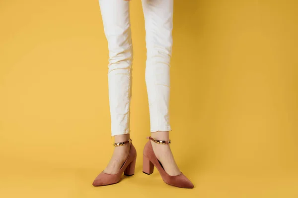Pies femeninos zapatos de moda de lujo fondo amarillo — Foto de Stock