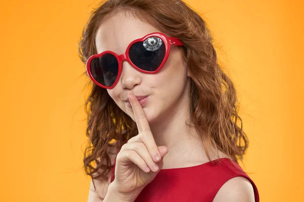 Chica en gafas negras vestido rojo infantil divertido fondo amarillo — Foto de Stock