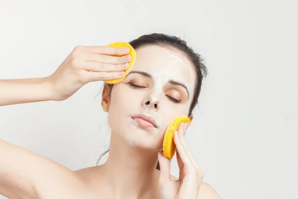 Woman naked shoulders sponges in hands mask on face — Stock Photo, Image