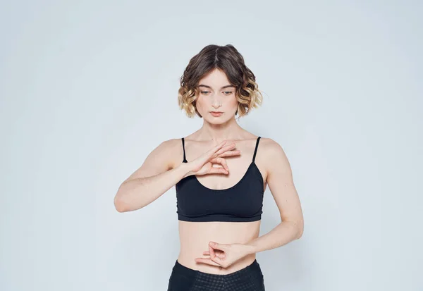 Mujer delgada en gestos de ropa deportiva con sus manos meditación yoga — Foto de Stock