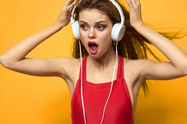 Mujer emocional con auriculares escuchar música fondo amarillo de cerca —  Fotos de Stock