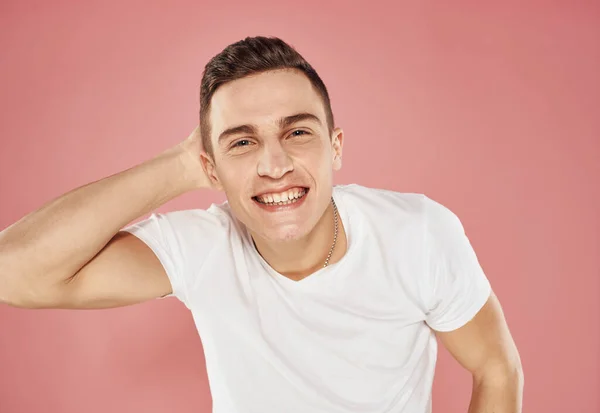 Man in white t-shirt emotions gestures with hands pink background — Stock Photo, Image