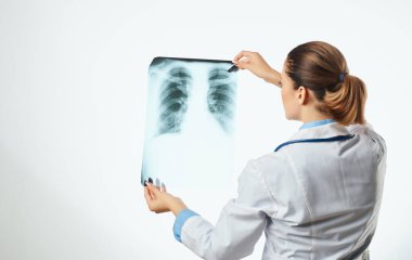 Kadın doktor röntgen ve steteskoplu gözlük takıyor.