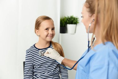 Steteskoplu bir doktor çocuk hastanesi sağlığını kontrol ediyor.