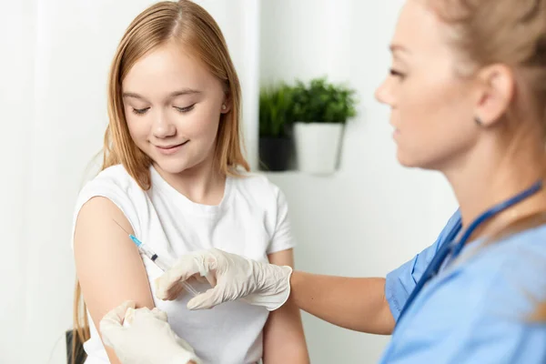 Kvinnlig läkare ger en flicka en injektion i armen vaccination — Stockfoto