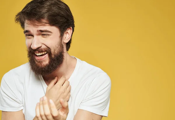 Uomo felice con la barba gesti con le mani su uno sfondo giallo Copia spazio — Foto Stock