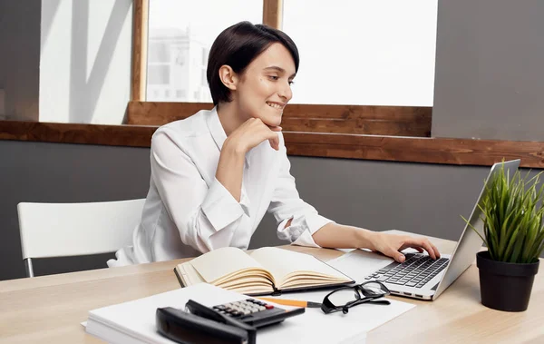 Obchodní žena sedí u pracovního stolu před finanční kanceláří notebooku — Stock fotografie