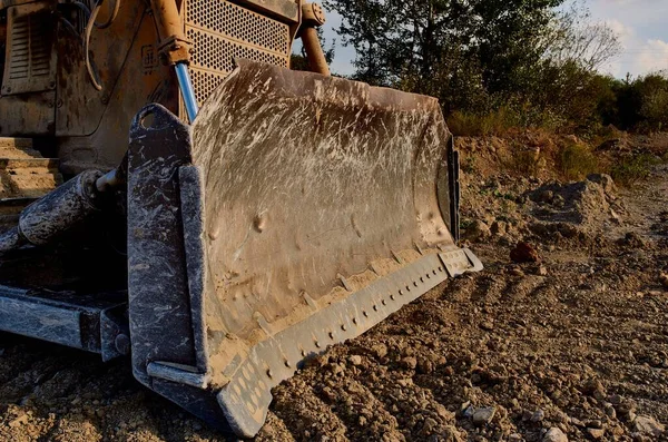 Camion terreno di scavo per la costruzione escavatore ghiaia alberi di sabbia cielo blu — Foto Stock