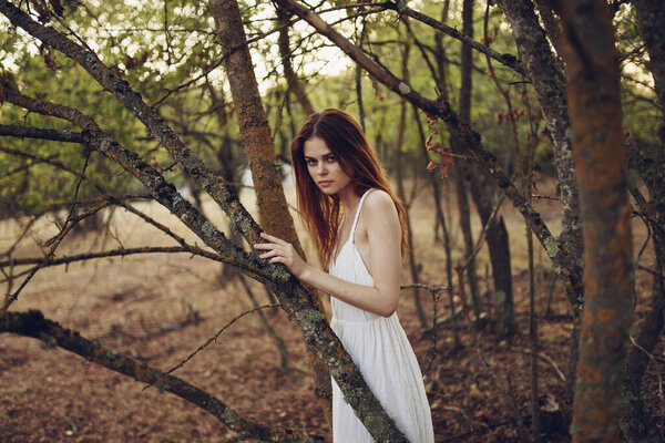 Romantic woman in nature near trees in the forest. High quality photo