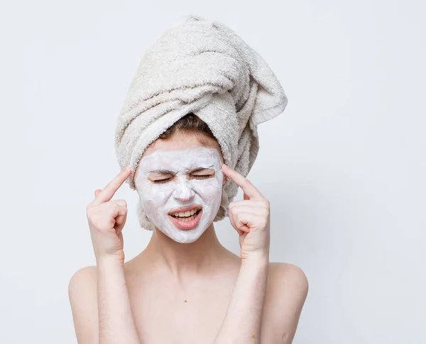 Woman with a white mask against black dots on her face and a towel on her head — Stock Photo, Image