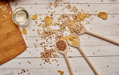 Tahta kaşıklar mutfak tahtasına saçılmış buğday ve tahıl.