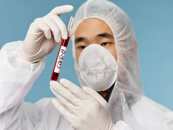 Muž asijského vzhledu Laboratoř krevní test diagnostika close-up modré pozadí — Stock fotografie