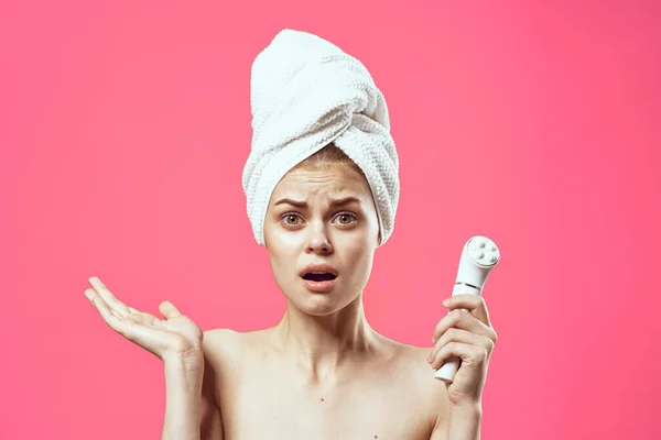 Mooie vrouw naakt schouders handdoek op hoofd gezicht massage roze achtergrond — Stockfoto