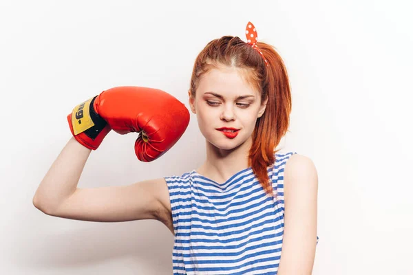 Boxeador mujer en guantes rojos y en una camiseta a rayas modelo brazo muscular — Foto de Stock