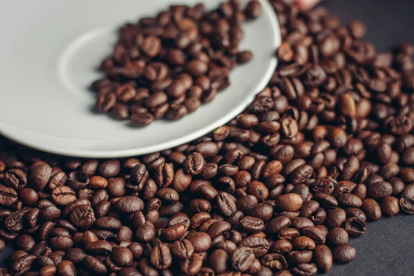 Šálek kávy s hnědými fazolemi na šedém pozadí detailní záběry makrofotografie — Stock fotografie