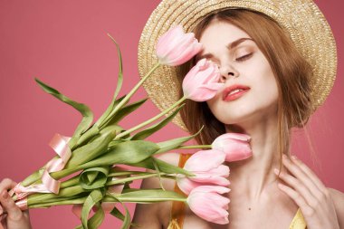 Neşeli kadın çiçek buketi hediye olarak tatil için pembe arka plan