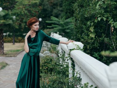 Yeşil elbiseli kadın zarif bir şekilde romantizm içinde yürüyor.