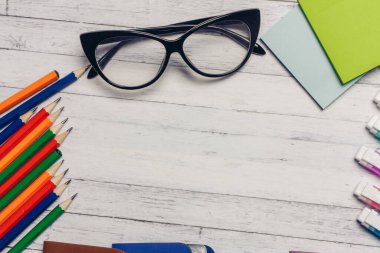 Kırtasiye kartı sahipleri tahta masa ofis malzemelerinin üzerine renkli kalemler.