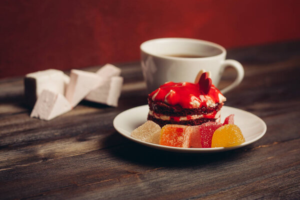 Round red cake In a saucer a cup of tea sweets delight candy