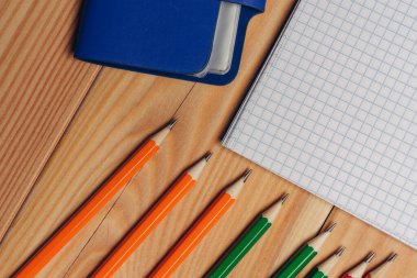 Çalışma masasında çok renkli kalemler var. Ahşap arka plan ofisi yakın plan.