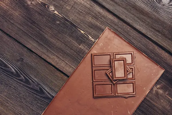 Barra de chocolate doce no fundo de madeira e doces textura de doces — Fotografia de Stock