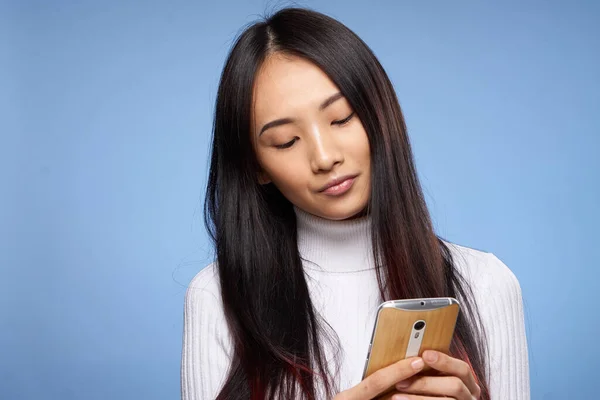 Frau asiatisch Aussehen Telefon Hände Kommunikationstechnologie Lifestyle blauer Hintergrund — Stockfoto