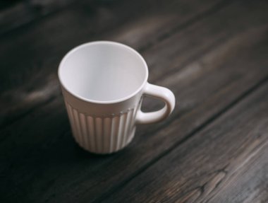 Masanın üzerindeki beyaz kupa. Üst görünüm.