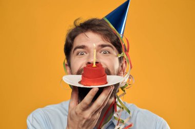 Sarı bir arka plan tatilinde elinde pasta olan bir adam manzarayı kesmiş.