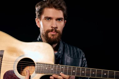 Elinde gitar olan bir adam deri ceketli müzik performansı rock yıldızı modern tarz koyu arkaplan