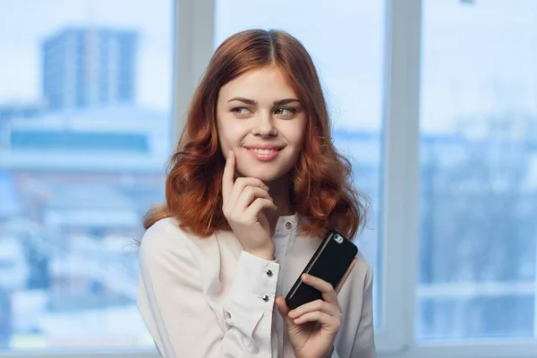 Geschäftsfrau im weißen Hemd mit Telefon in der Hand kommuniziert — Stockfoto