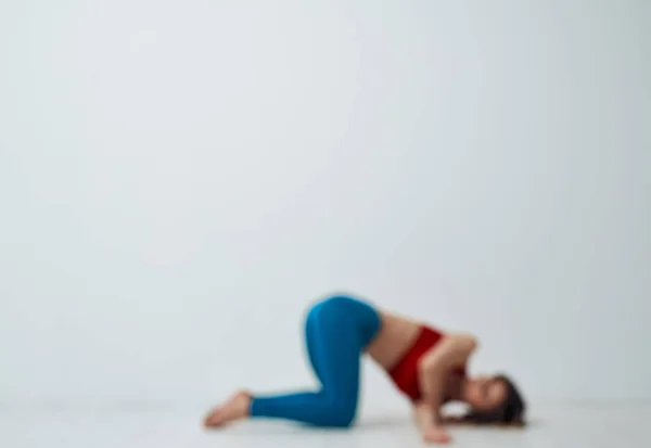 Yoga exercises slim woman blue leggings red tank top — Stock Photo, Image