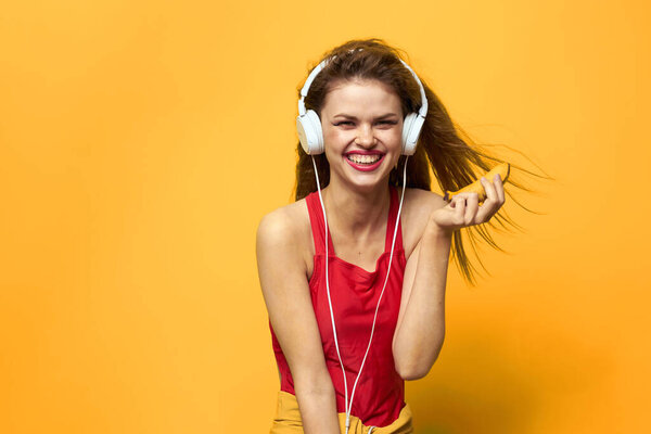 Emotional woman in white headphones listens to music fun lifestyle yellow background