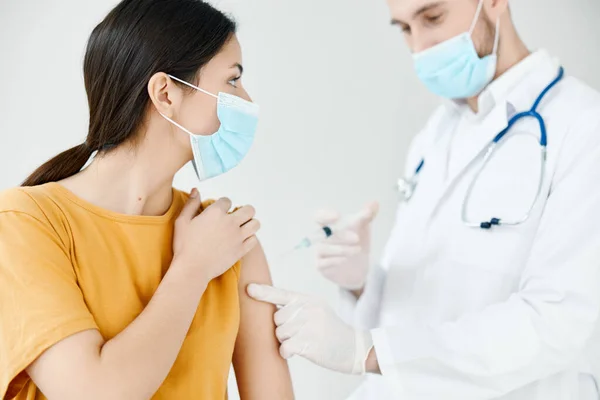 Il paziente in maschera medica guarda il medico con una siringa in mano vaccinazione covid — Foto Stock