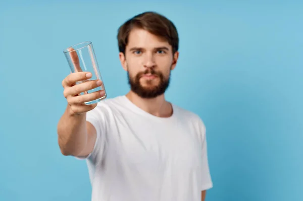Hombre feliz con vaso de agua sobre fondo azul bebida estilo de vida — Foto de Stock