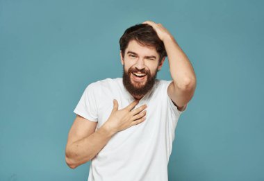 Neşeli adam elleriyle kafasına dokunuyor mutluluk duyguları mavi arka plan